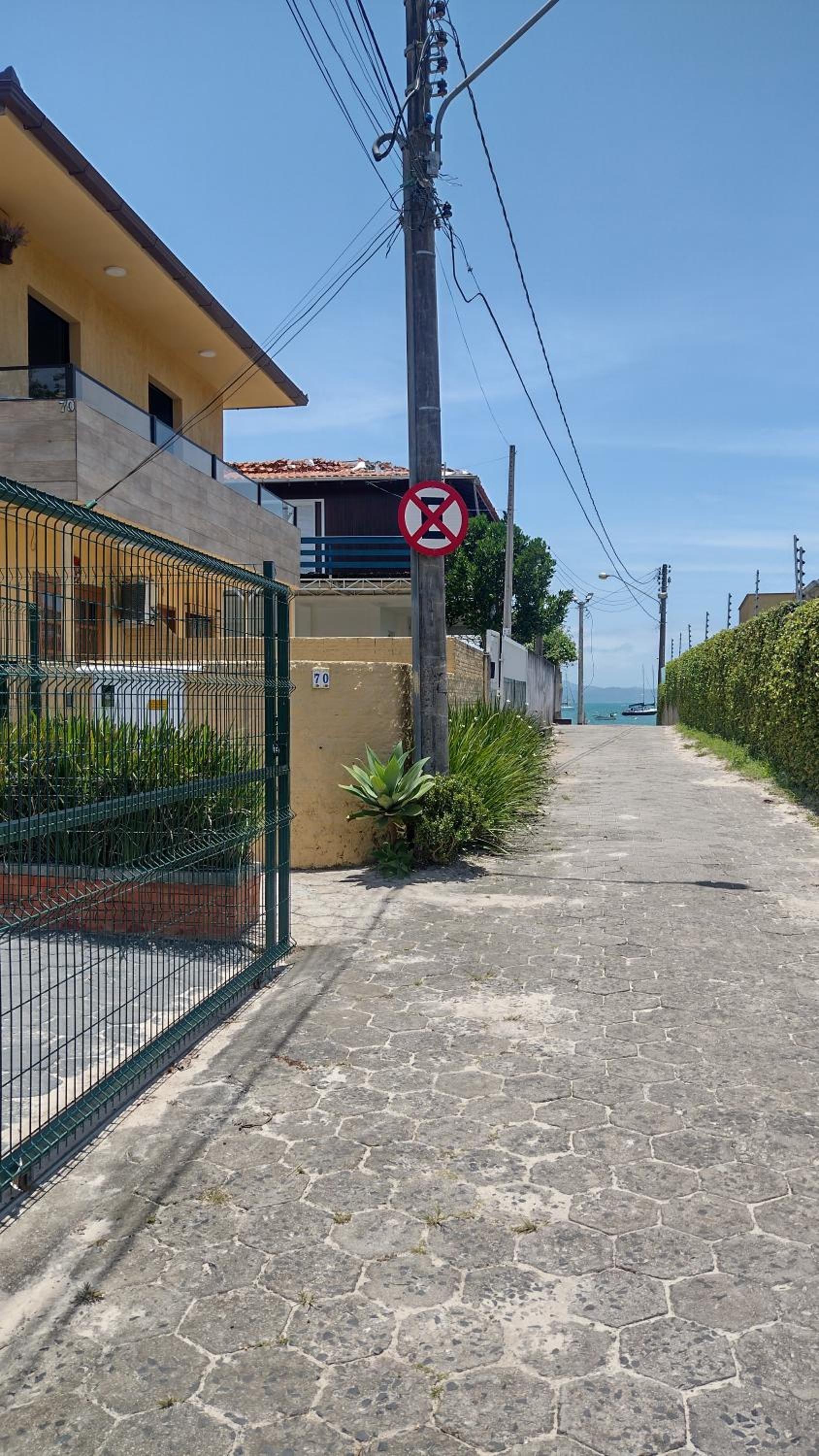 Rua de lajotas ao lado do prédio, seguindo em direção à praia