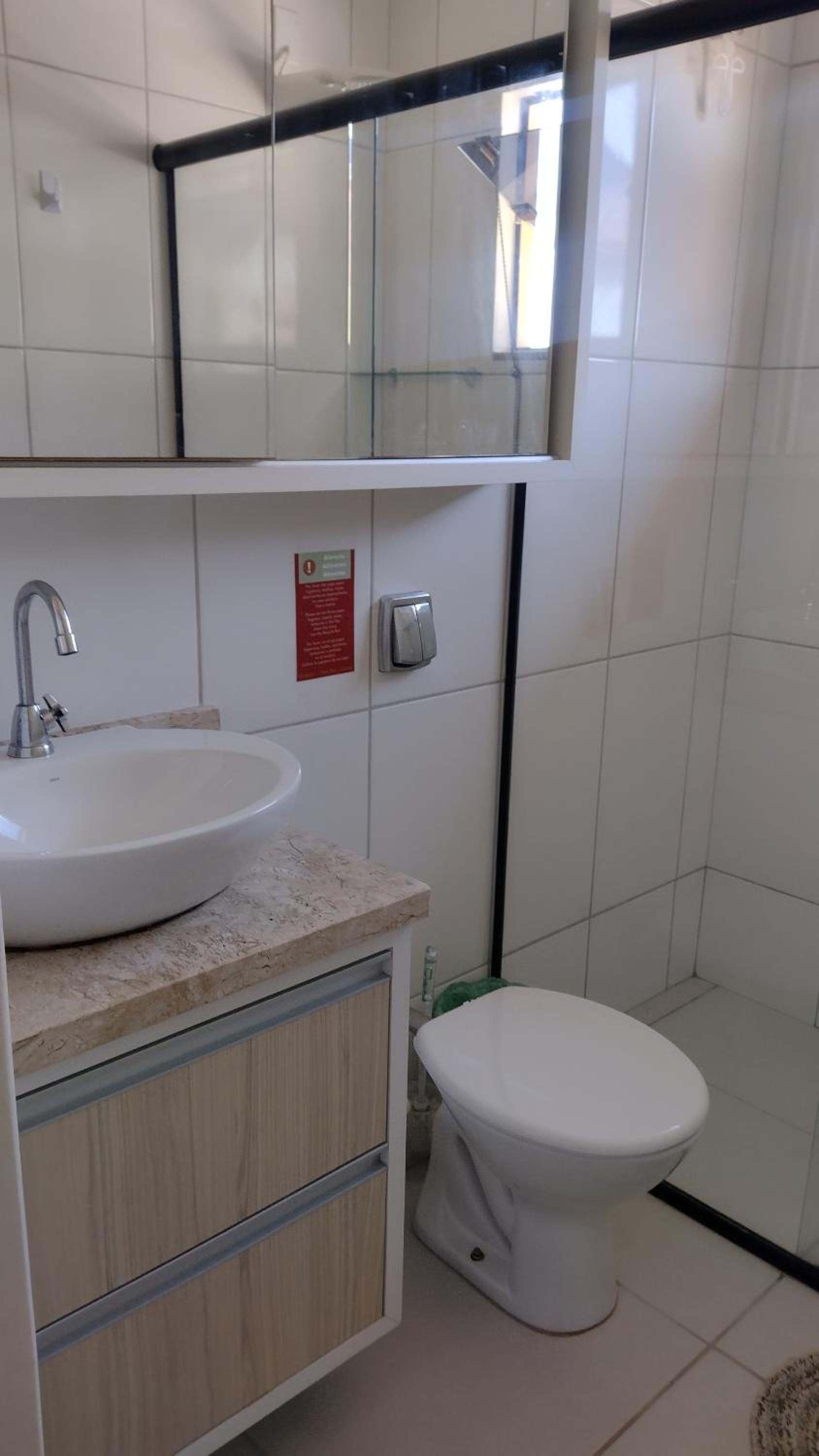 Banheiro do Apto 4 com cuba redonda sobre bancada, vaso e box de vidro