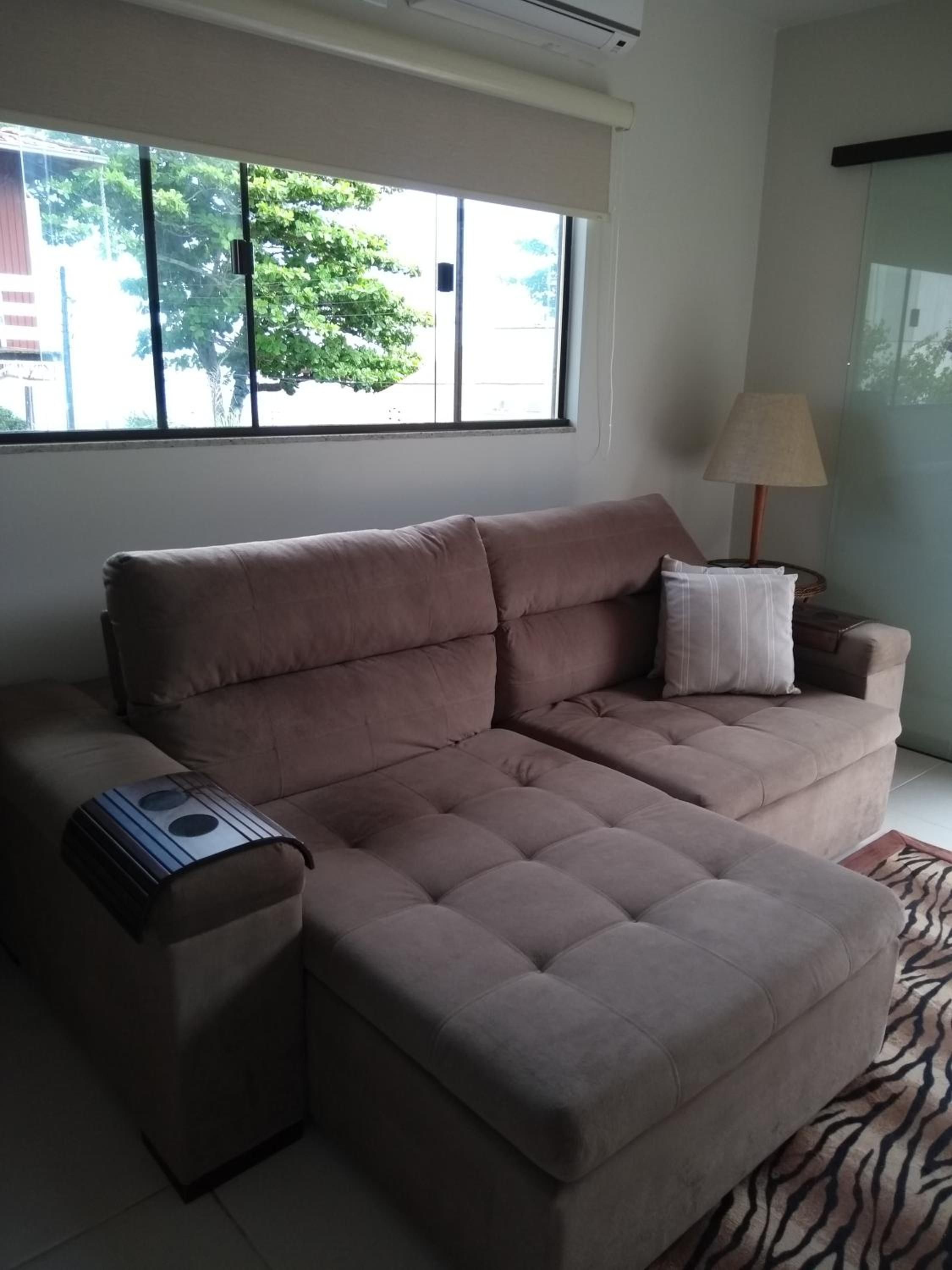 Sofá-cama do Apto 4 com o assento puxado, ao lado da janela