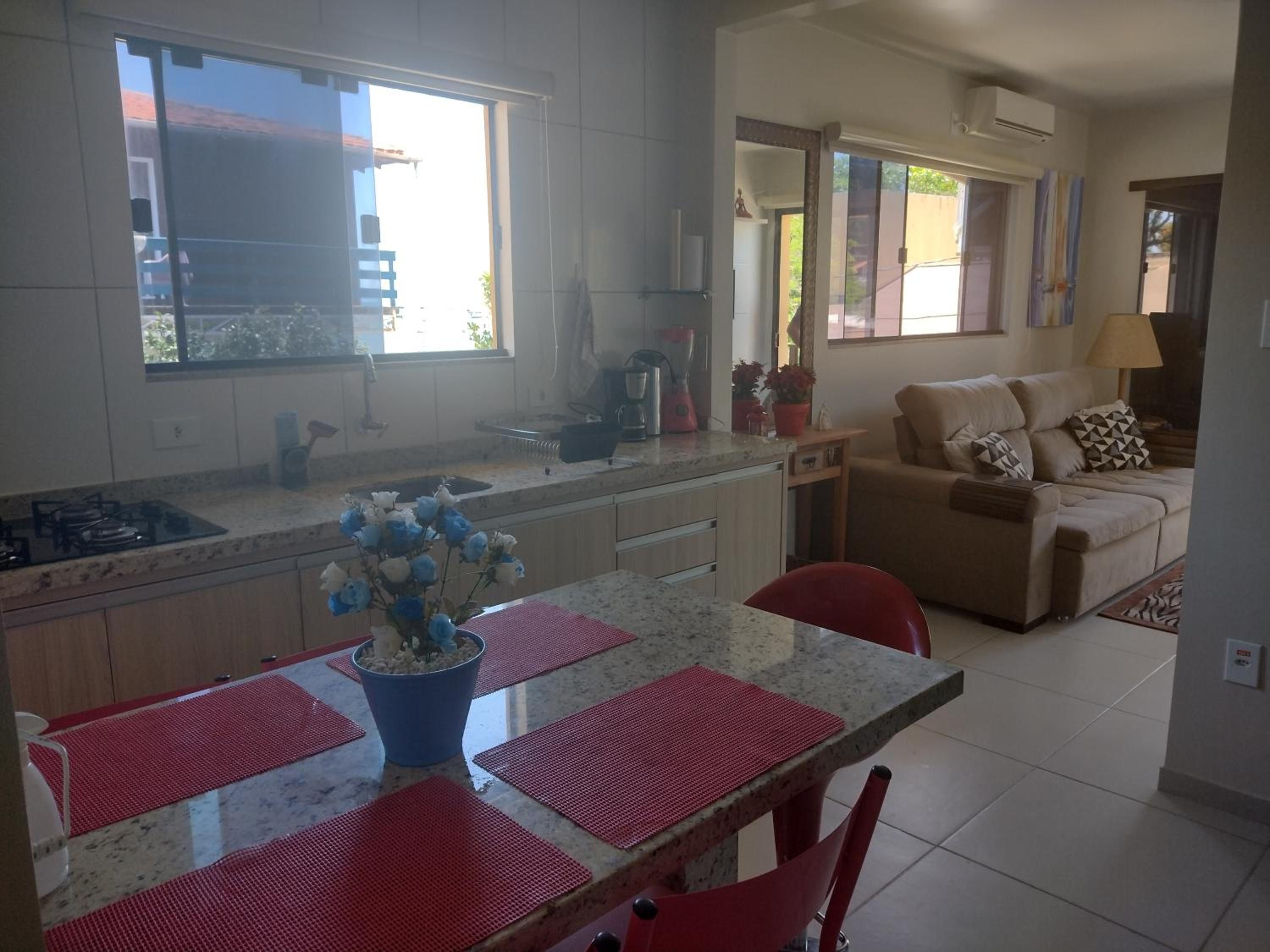 Mesa de granito posta no Apto 4, com a cozinha e a sala ao fundo