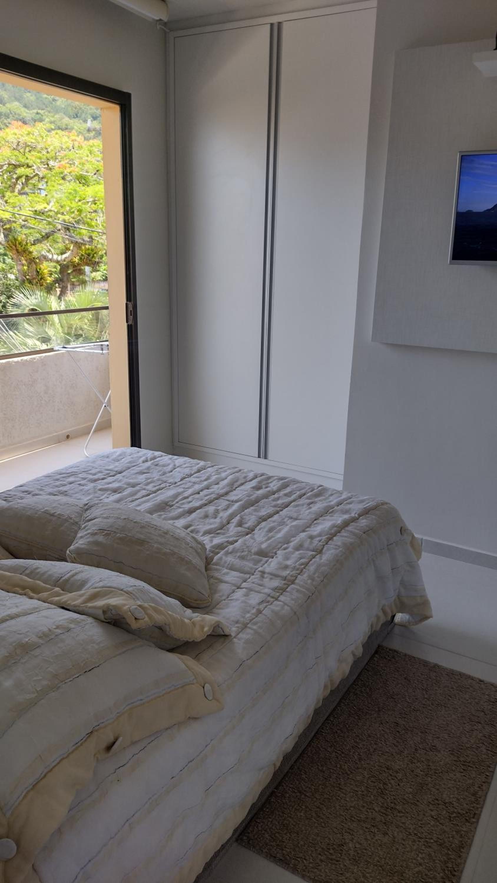 Quarto do Apto 4 com cama de casal e porta aberta para a varanda